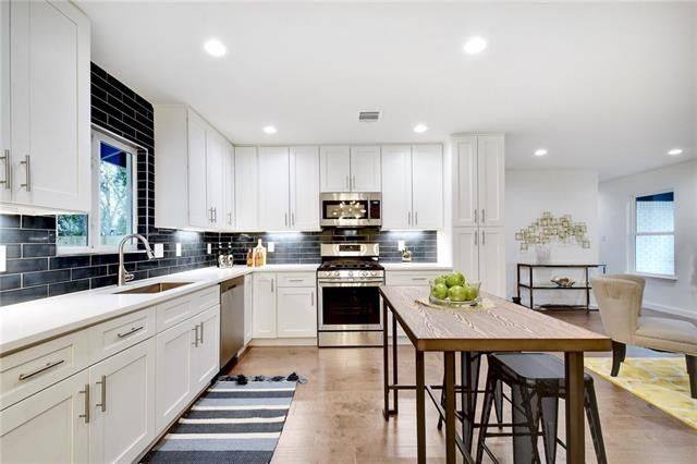 A modern kitchen featuring sleek white cabinets paired with a stylish black countertop, creating a contemporary aesthetic.