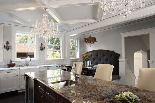 A spacious kitchen featuring a large island and an elegant chandelier, creating a bright and inviting atmosphere.