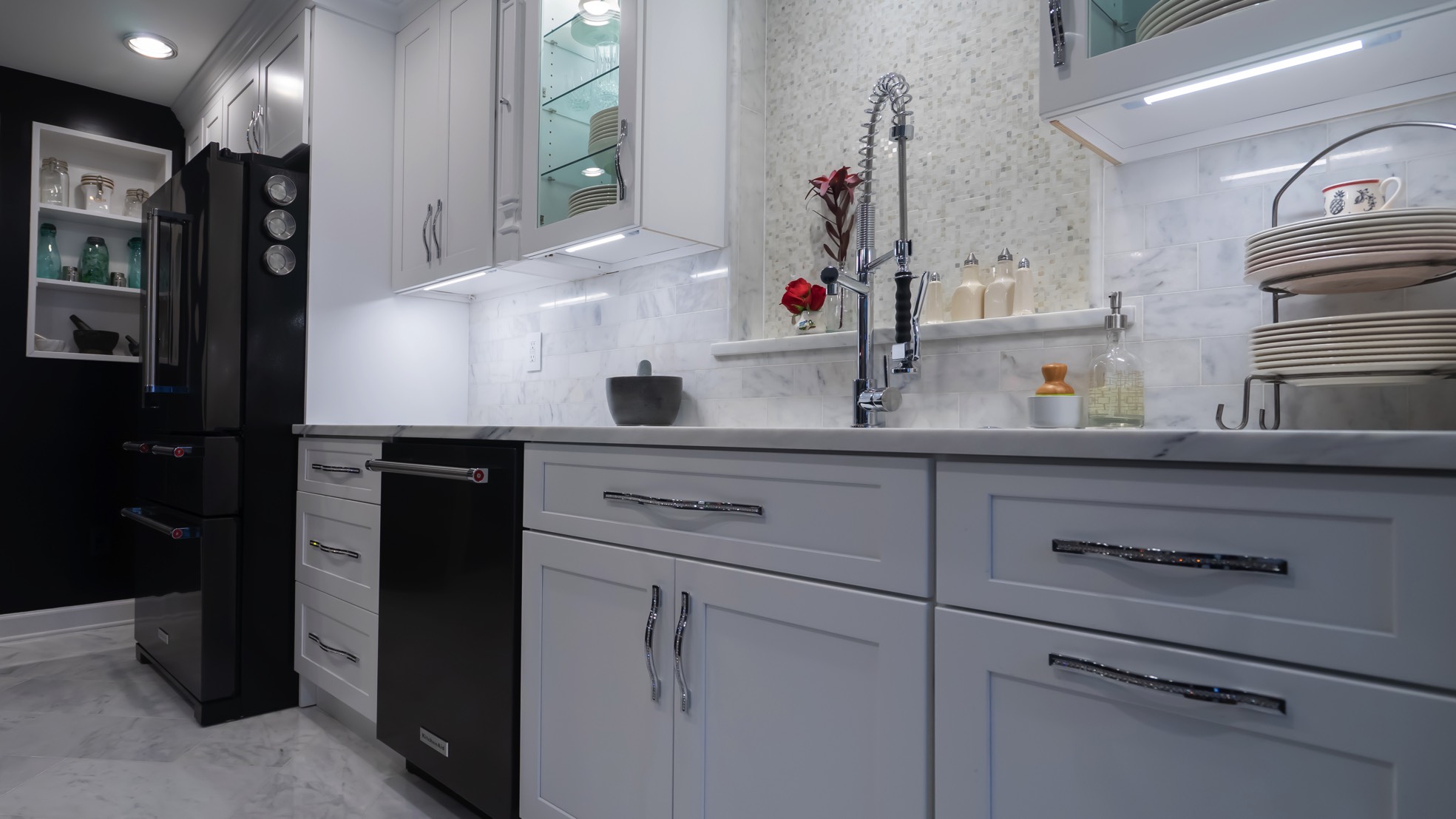 A modern kitchen featuring sleek black and white cabinets alongside a stylish black refrigerator, creating a contemporary aesthetic.