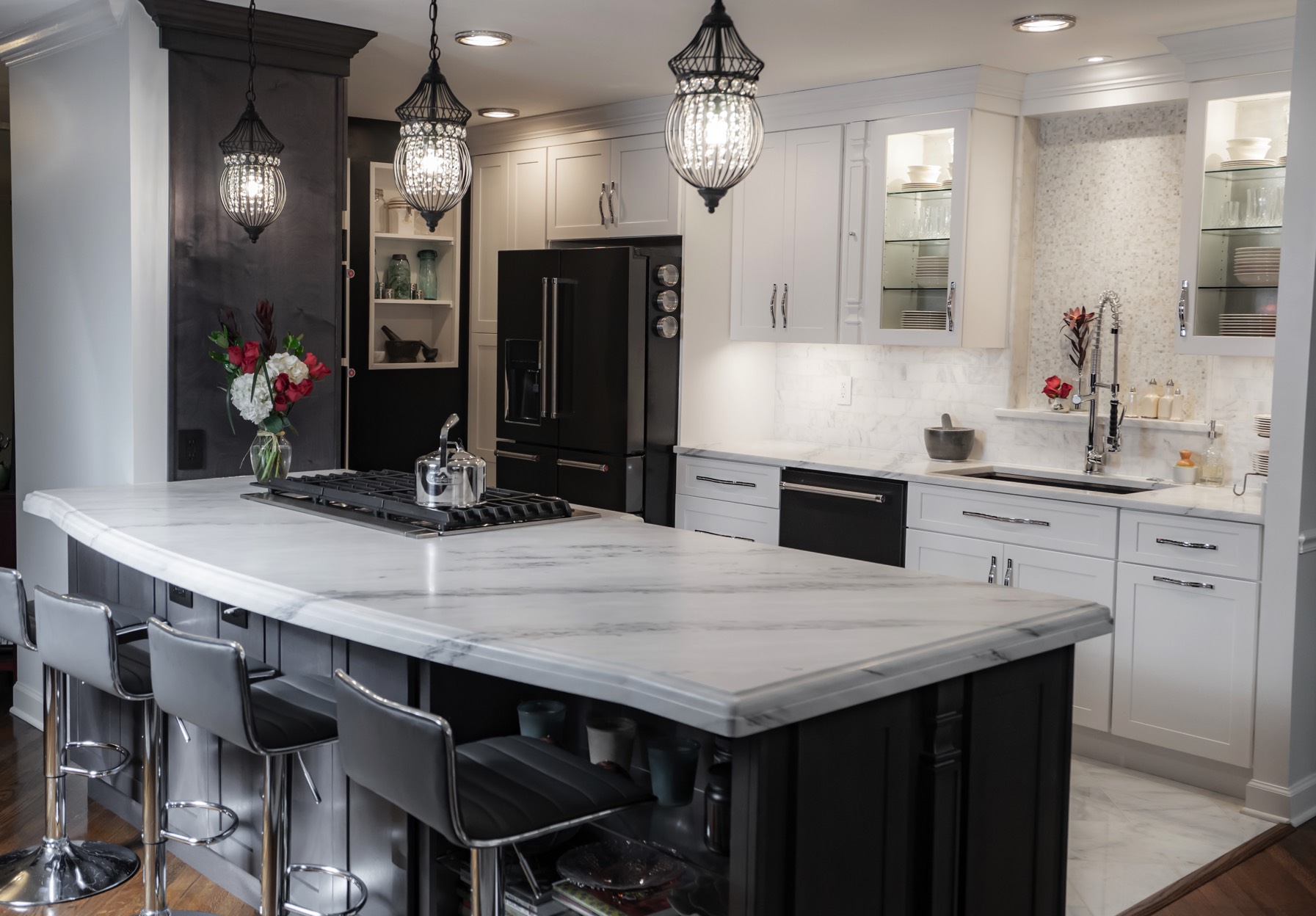 A contemporary kitchen showcasing a polished marble island with elegant bar stools arranged around it.