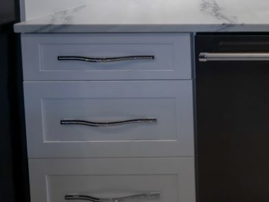 A modern kitchen featuring a sleek black and white marble countertop, enhancing the elegant design of the space.