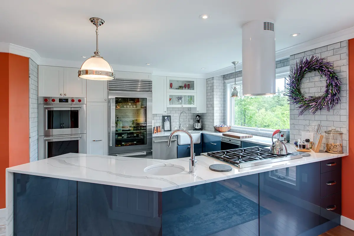 A kitchen featuring blue cabinets complemented by vibrant orange walls, creating a lively and modern atmosphere.