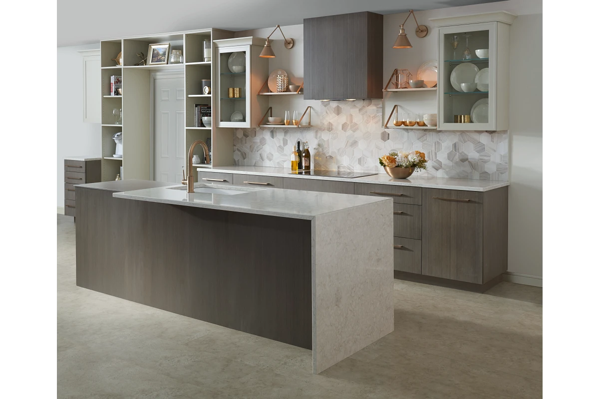 A spacious kitchen featuring a large island with a sink, surrounded by modern appliances and elegant cabinetry.