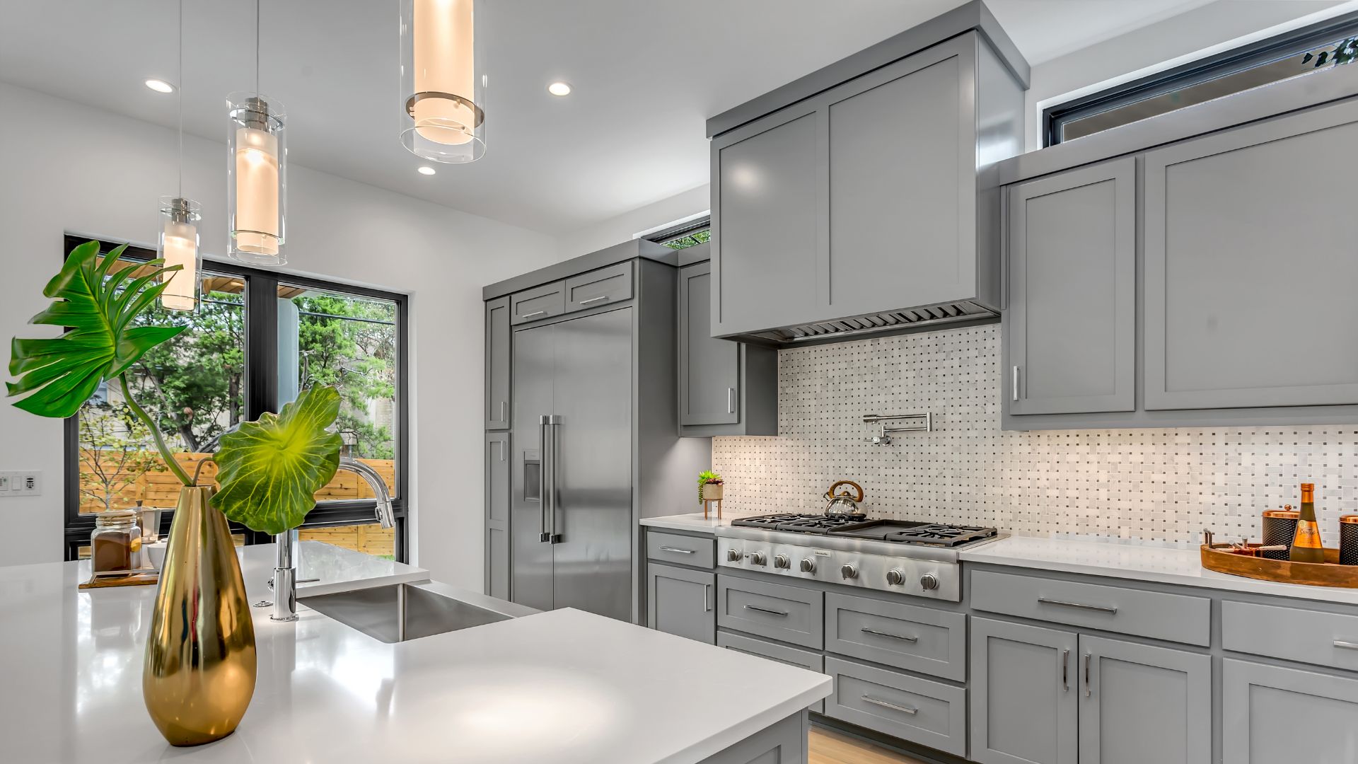 A modern kitchen featuring sleek gray cabinets and polished stainless steel appliances, showcasing contemporary design elements.