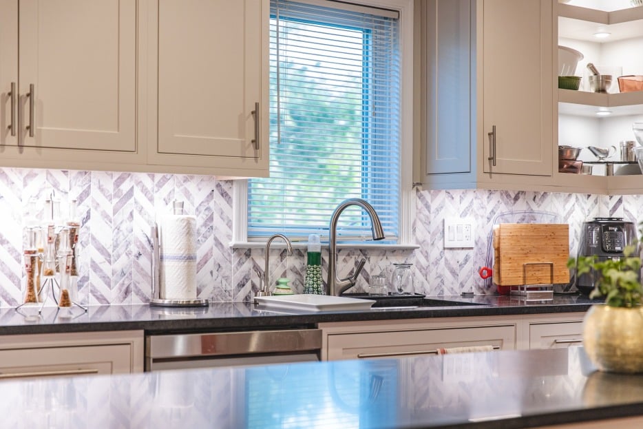 Bright kitchen showcasing white cabinetry and a contrasting black countertop, emphasizing a contemporary and sophisticated design.