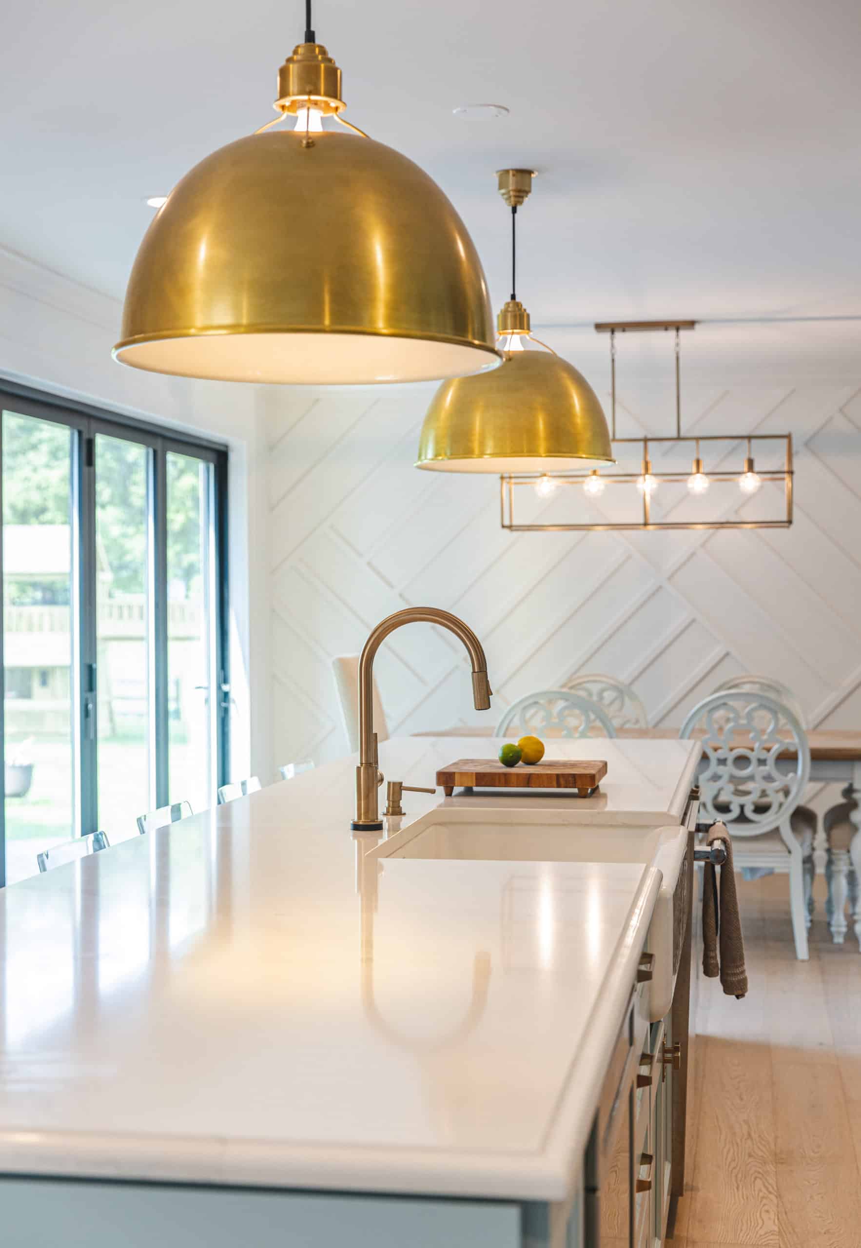 A modern kitchen featuring a spacious island and elegant brass pendant lights illuminating the space.