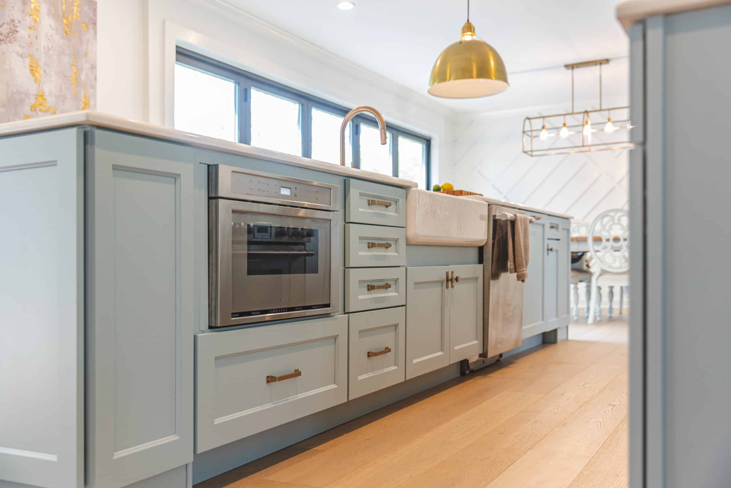 A contemporary kitchen design with a generous island and chic brass pendant lights enhancing the ambiance.