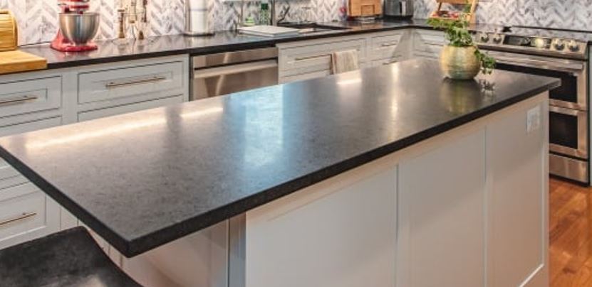 A modern kitchen featuring a sleek black countertop complemented by elegant white cabinets.