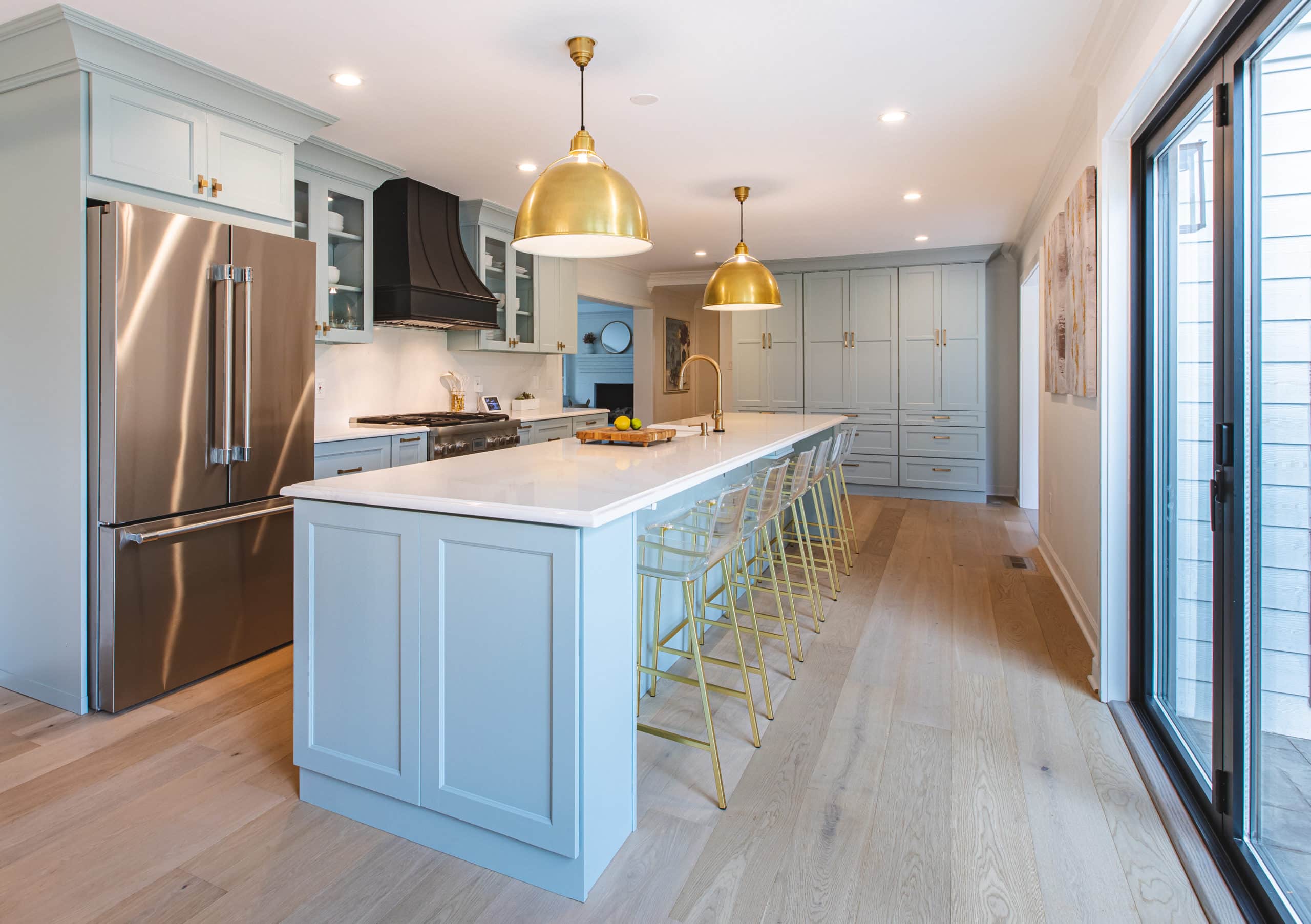 Light blue kitchen design in Ashburn VA with wood flooring and white countertop