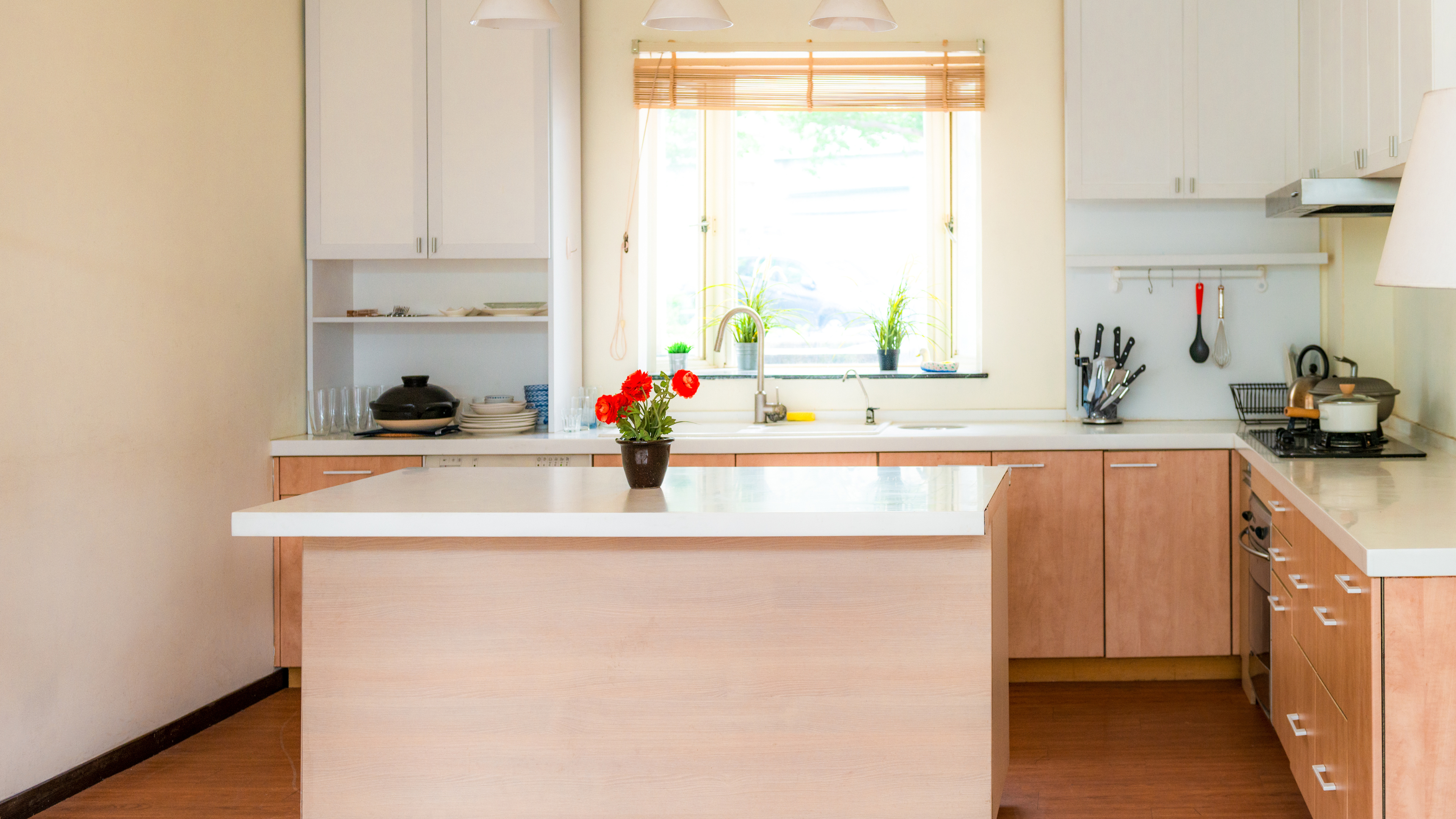 A modern white kitchen island featuring a sleek design, perfect for cooking and entertaining in a bright, airy space.