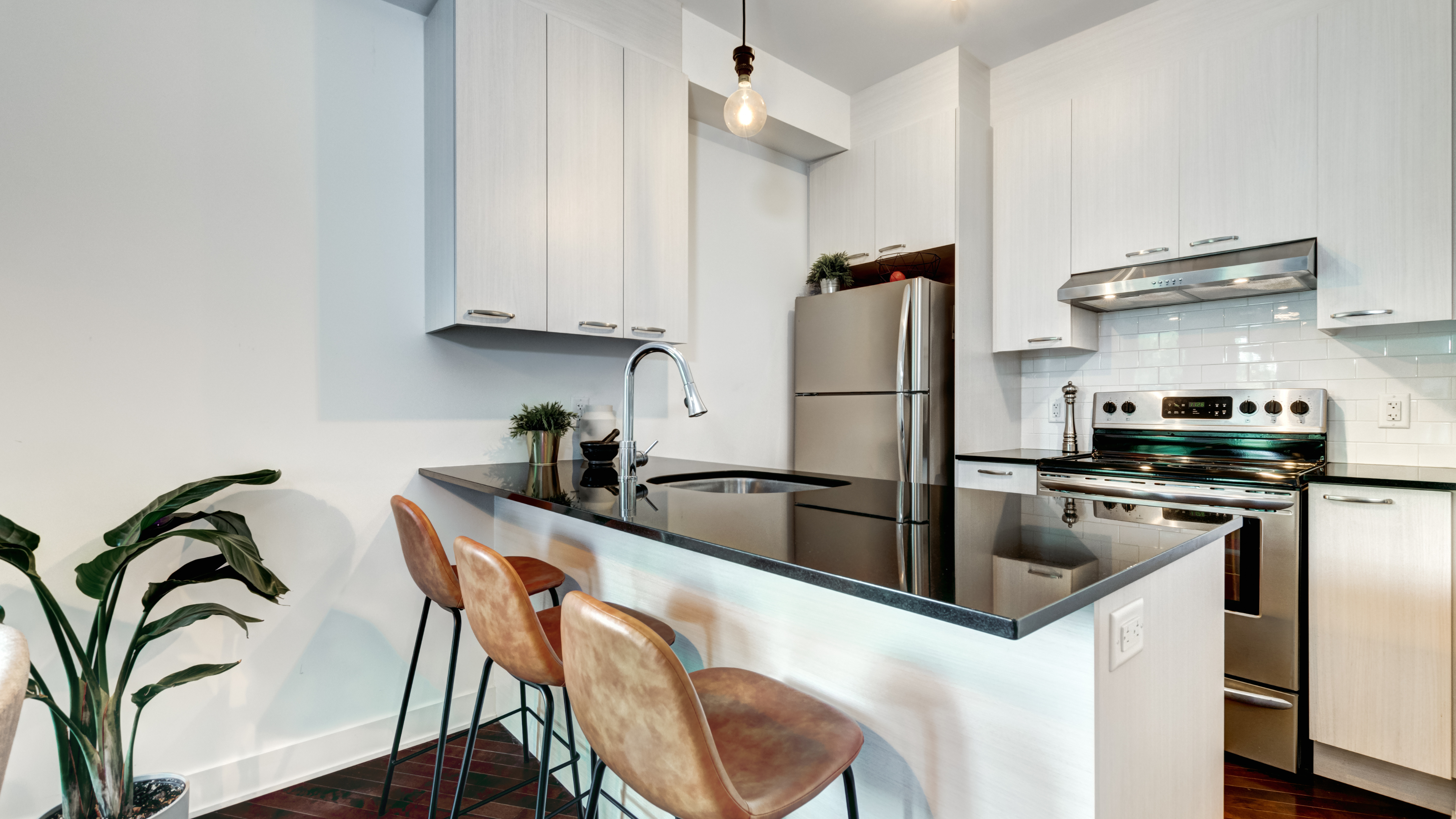 Silver white kitchen with black marble countertops