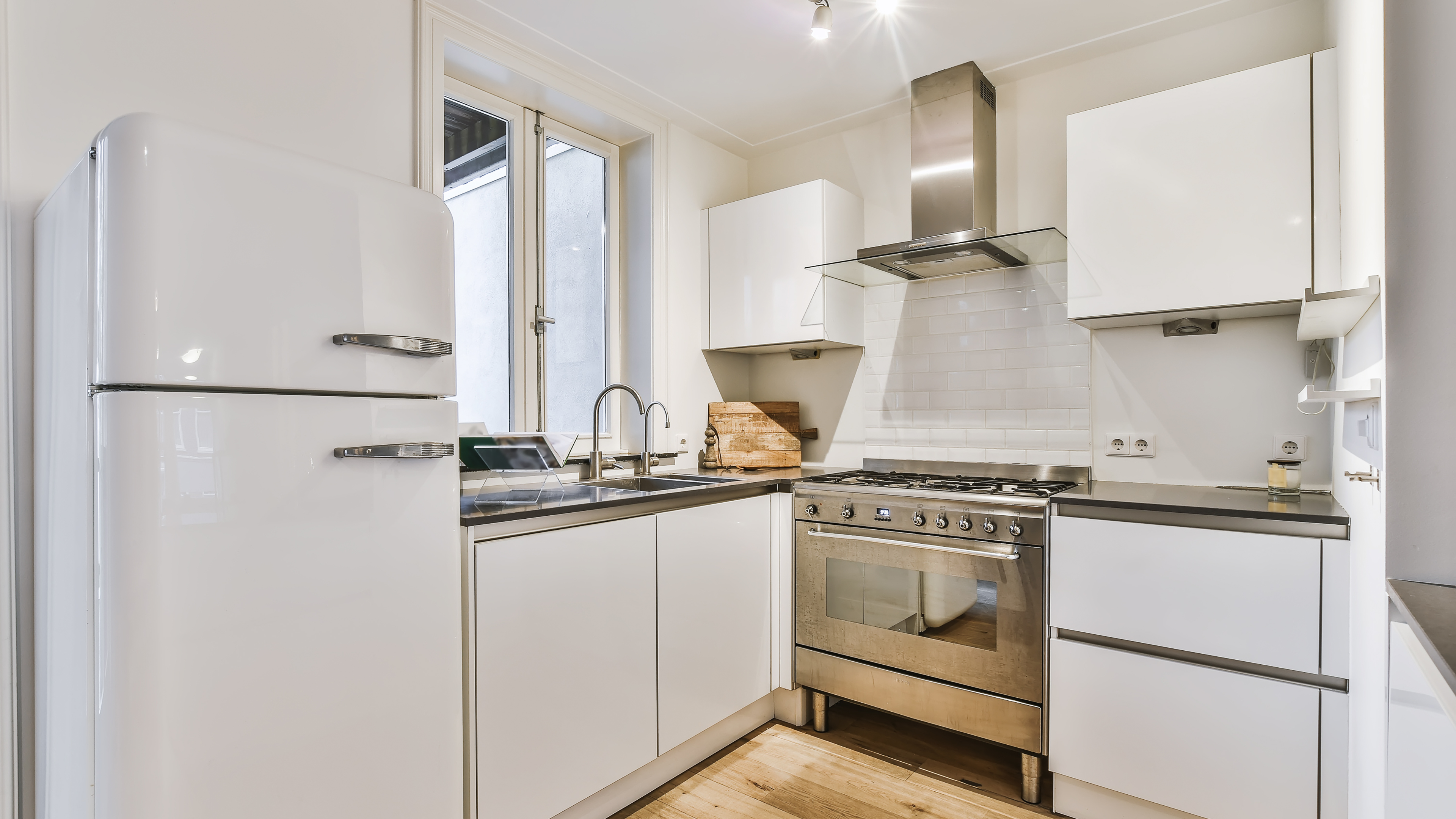 A modern kitchen featuring a refrigerator, stove, and oven, showcasing a clean and organized cooking space.