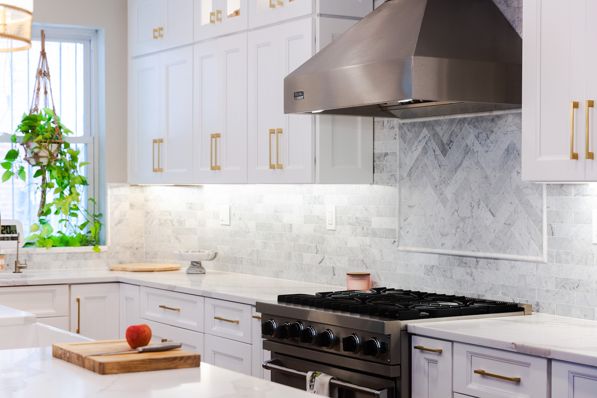 A modern kitchen featuring white cabinets and a sleek stove, creating a bright