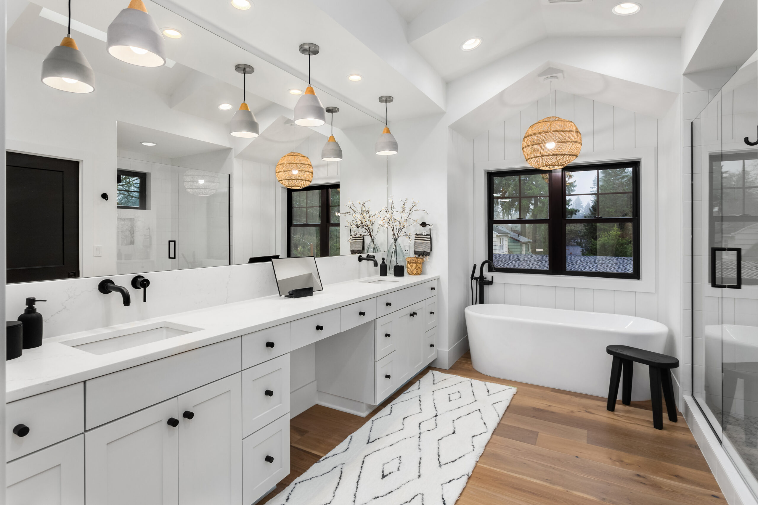 Bathroom in luxury home with double vanity, bathtub, mirror, sinks, shower, and hardwood floor