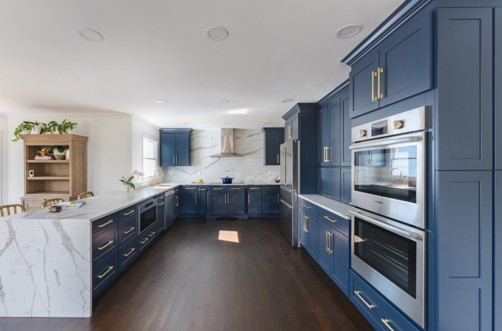 A modern kitchen featuring blue cabinets and a sleek marble countertop, creating a stylish and inviting atmosphere