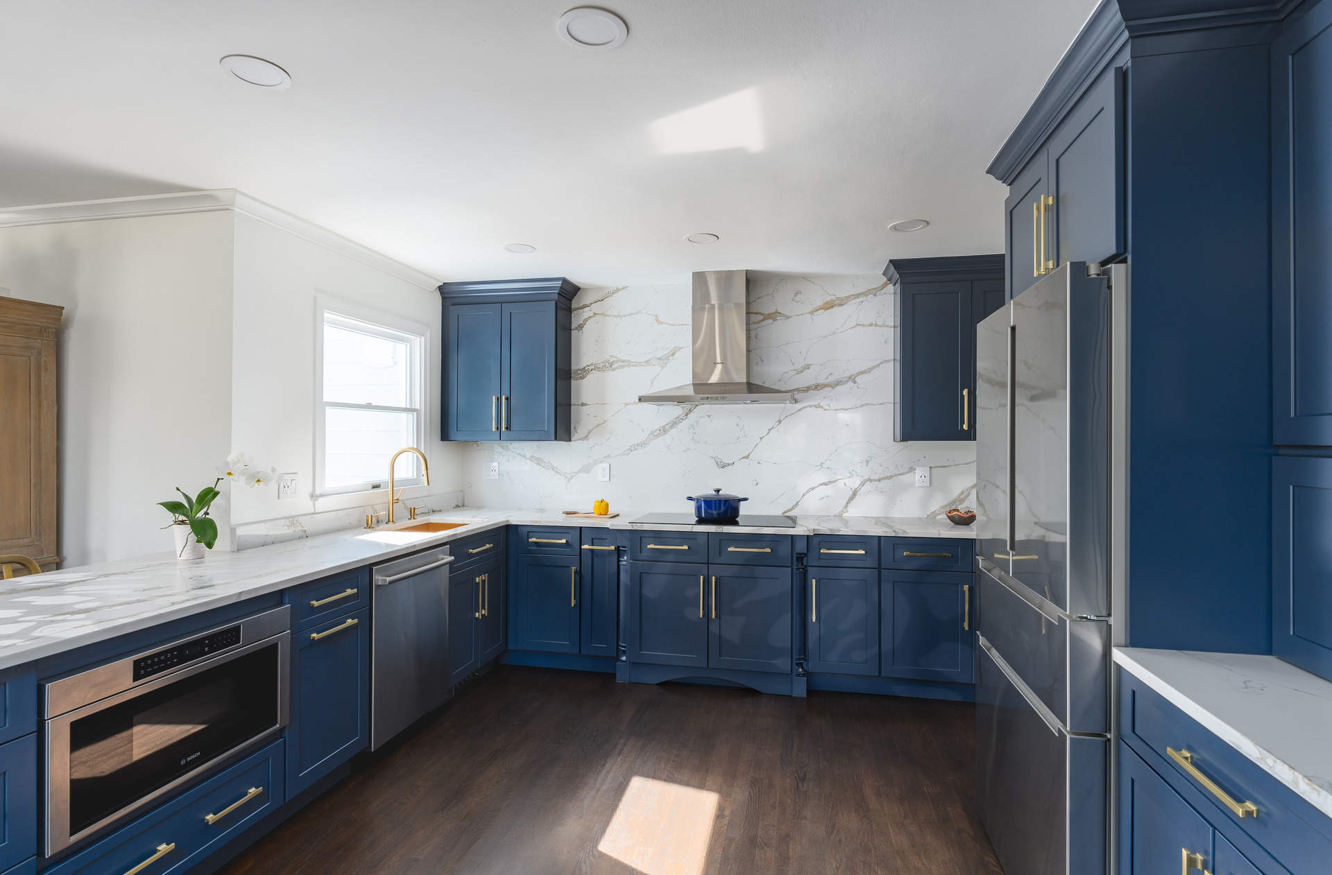 A stylish kitchen adorned with blue cabinets and a luxurious marble countertop, emphasizing a refined and modern look.