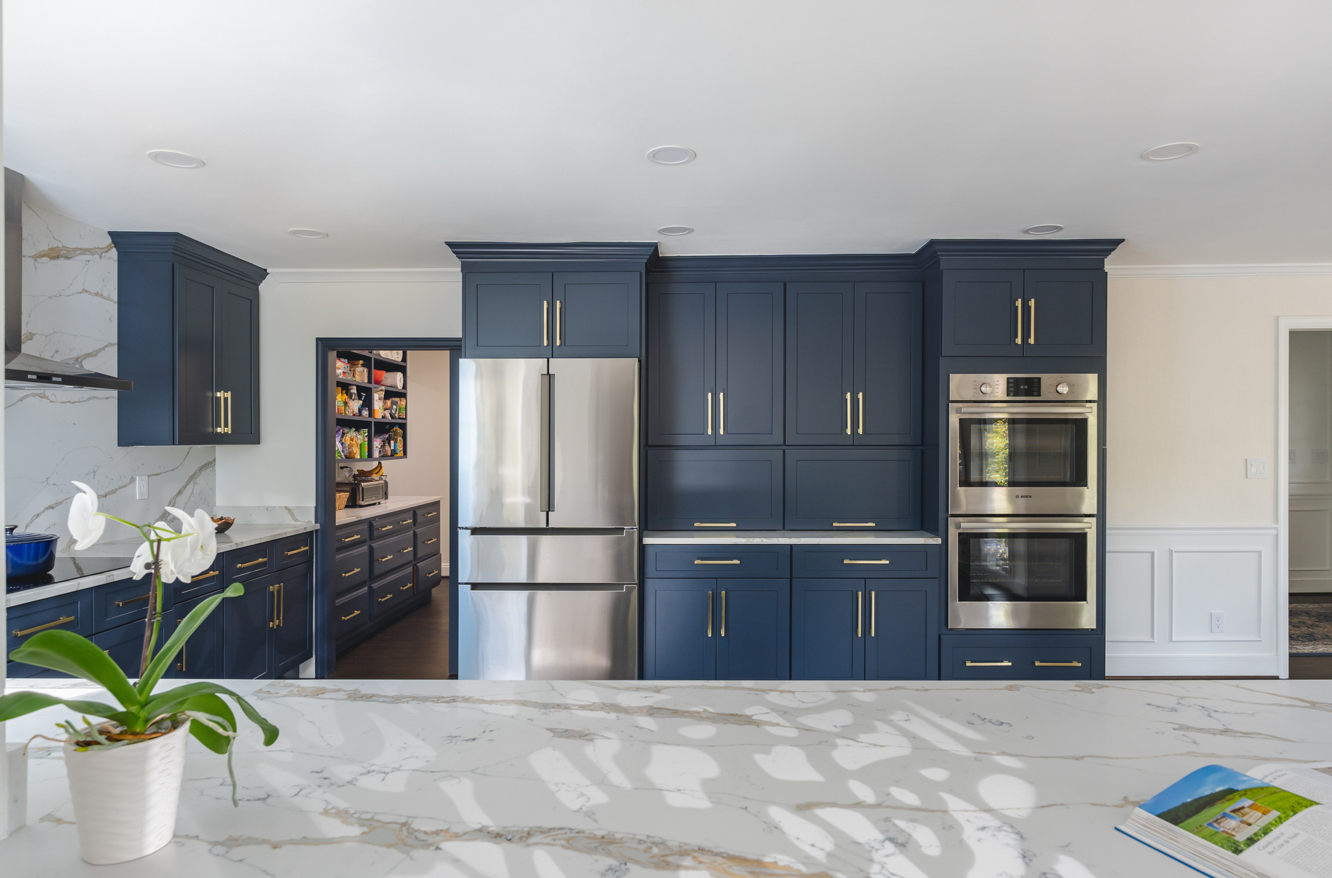 A beautifully designed kitchen showcasing blue cabinets and a stunning marble countertop, reflecting modern interior design trends.