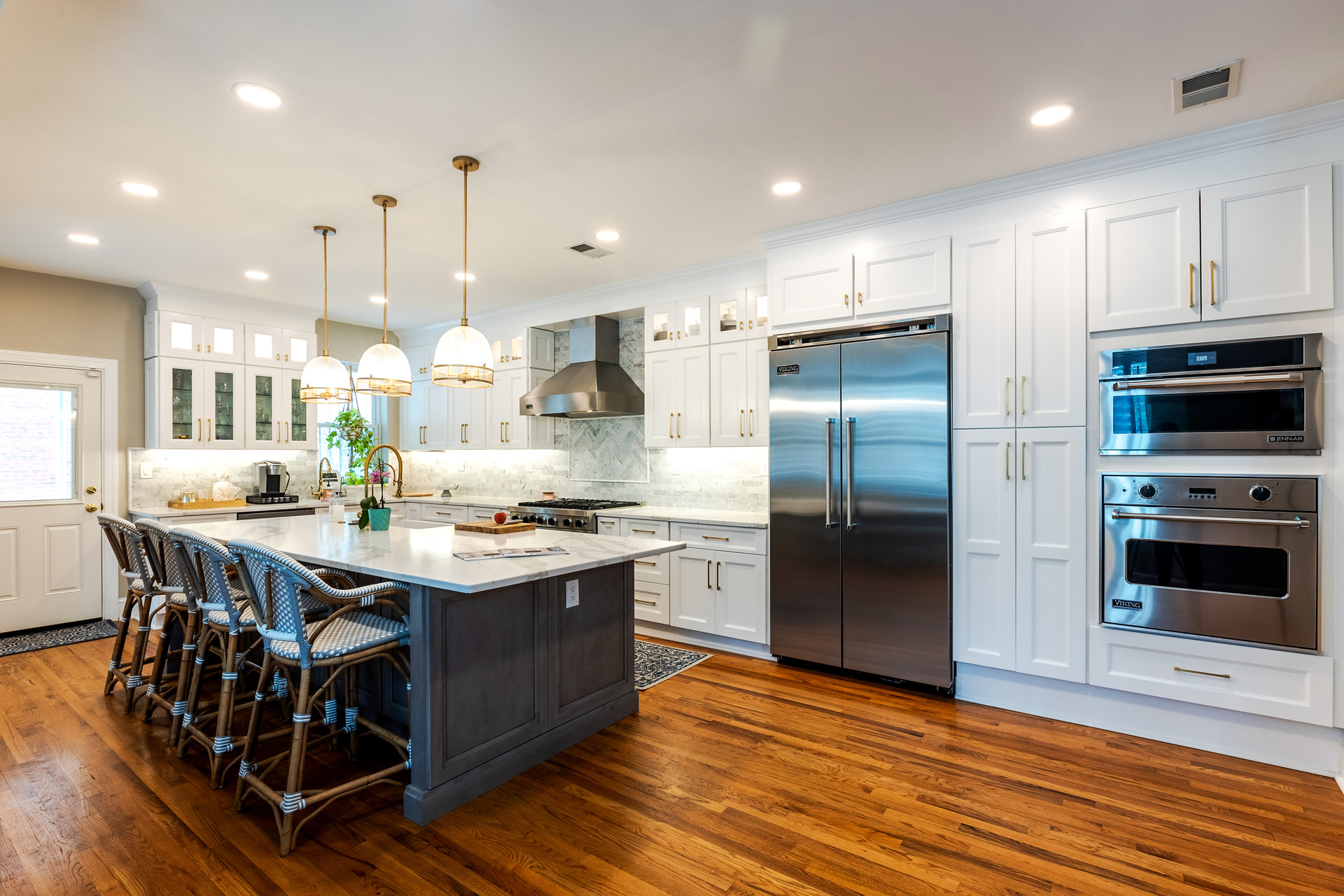 A modern kitchen featuring a sleek marble island and a spacious central island, showcasing elegant design and functionality.