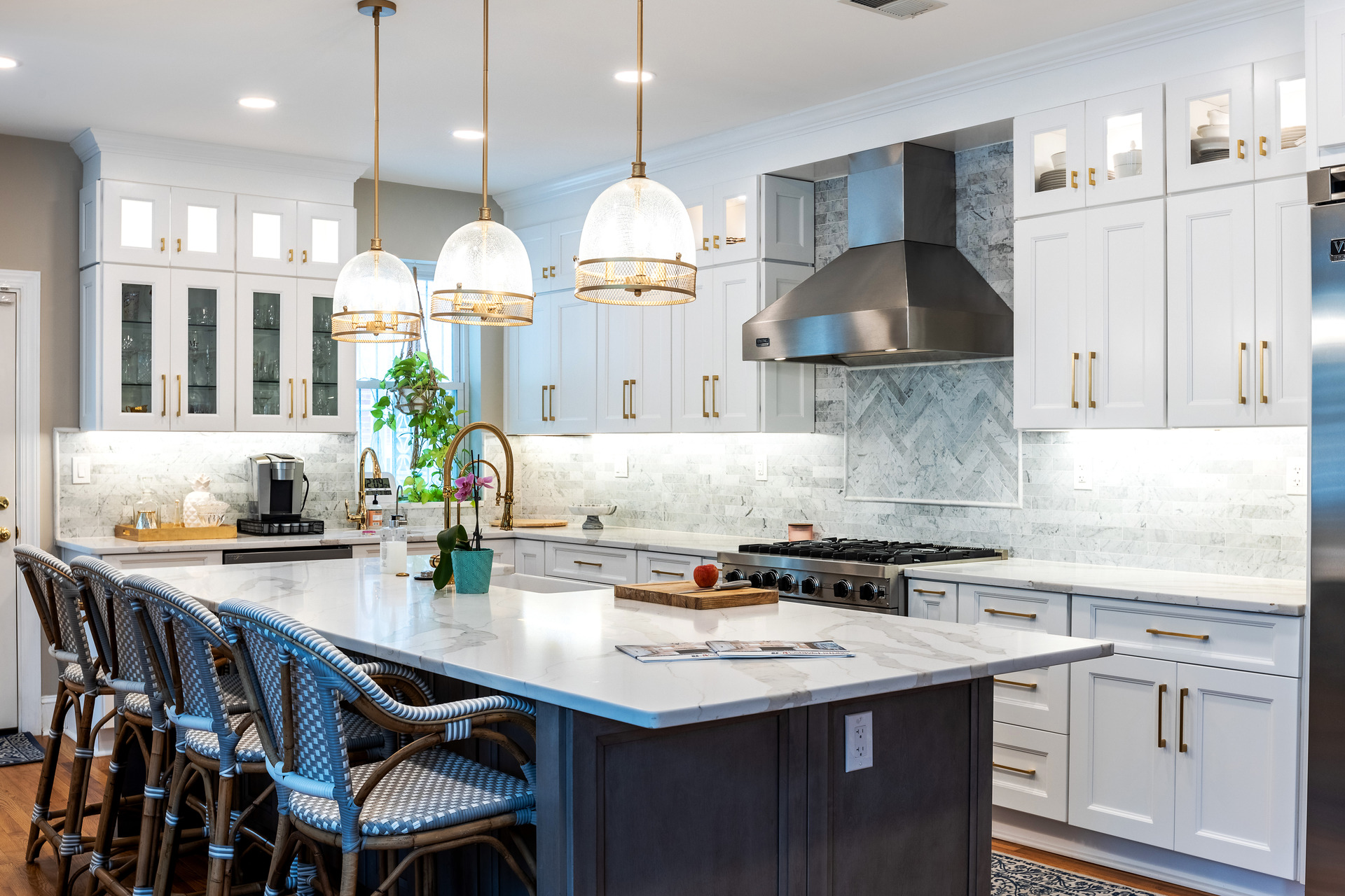 A modern kitchen featuring white cabinets and a sleek marble island, creating a bright