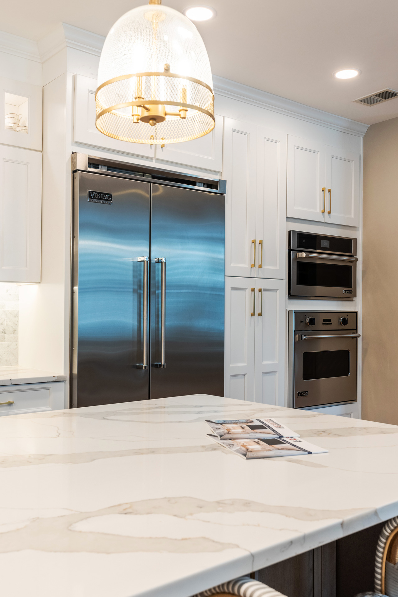 A modern white kitchen island featuring a sleek design, surrounded by elegant cabinetry and bright, airy lighting