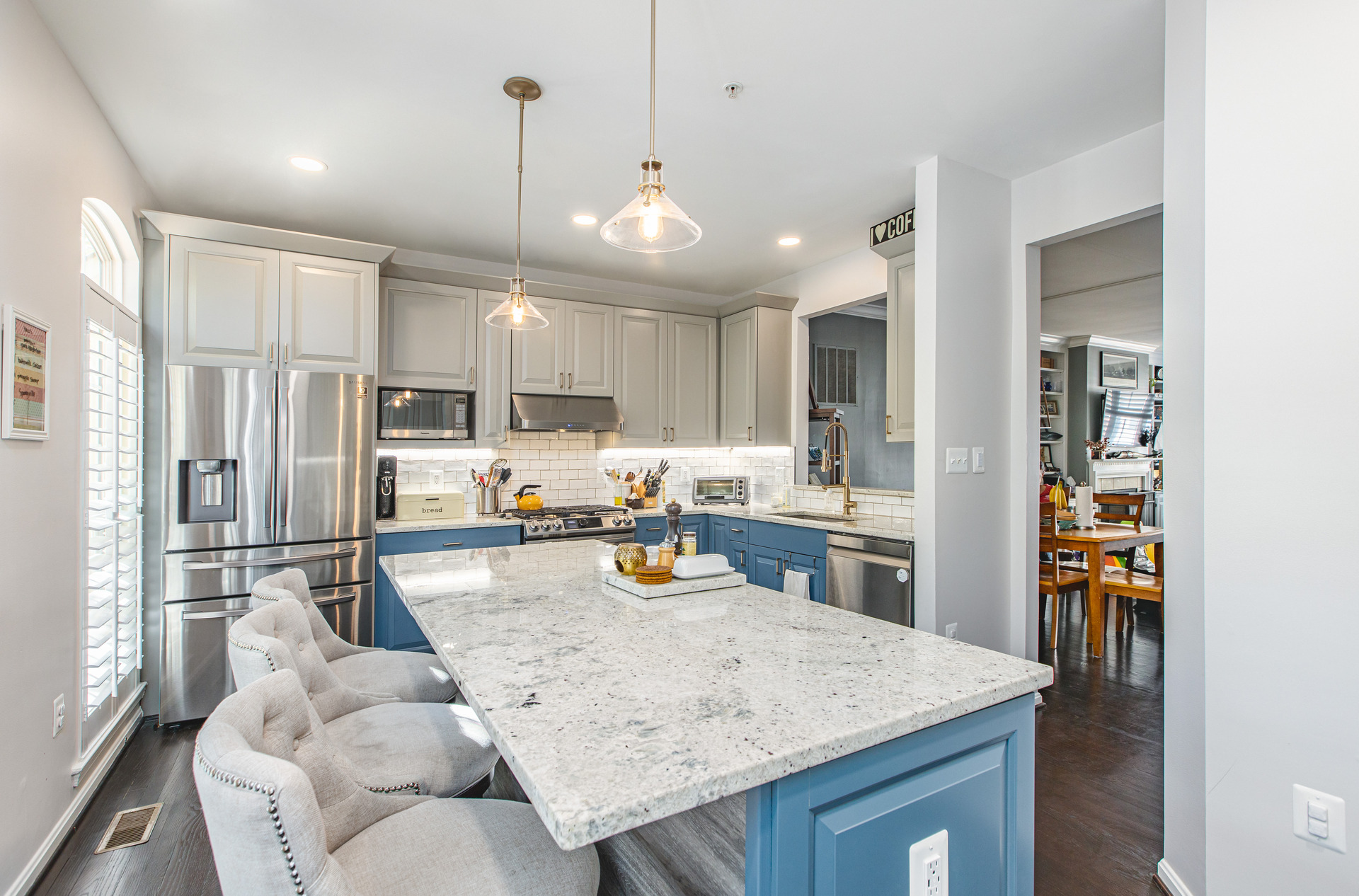 A modern kitchen featuring blue cabinets and a sleek marble island, showcasing a stylish and inviting atmosphere.