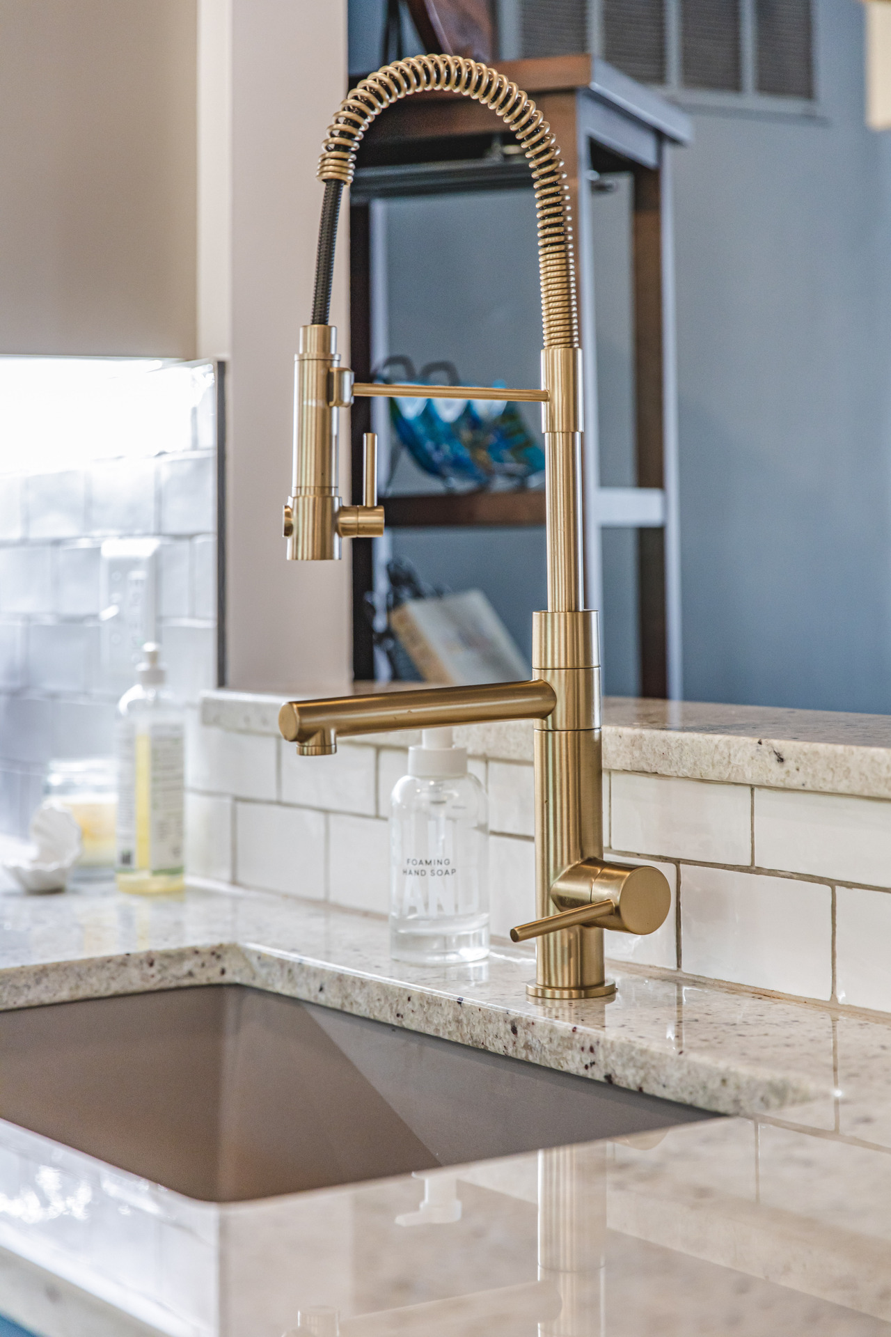 A kitchen sink featuring a polished brass faucet, showcasing a blend of elegance and functionality in a modern setting.