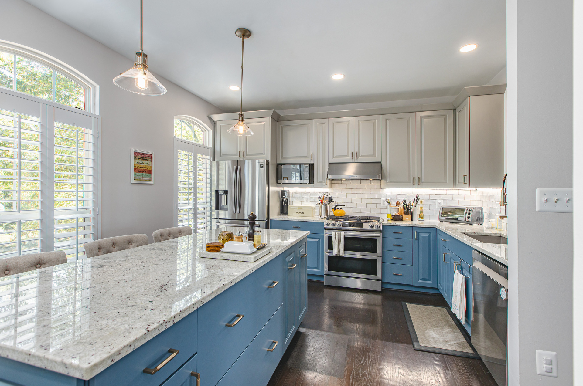 A contemporary kitchen design with vibrant blue cabinets and a polished marble island, emphasizing elegance and functionality.