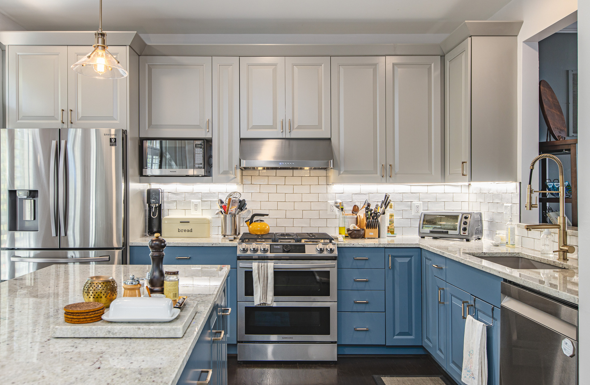 An elegant kitchen space adorned with blue cabinetry and a stunning marble island, creating a harmonious and chic environment.