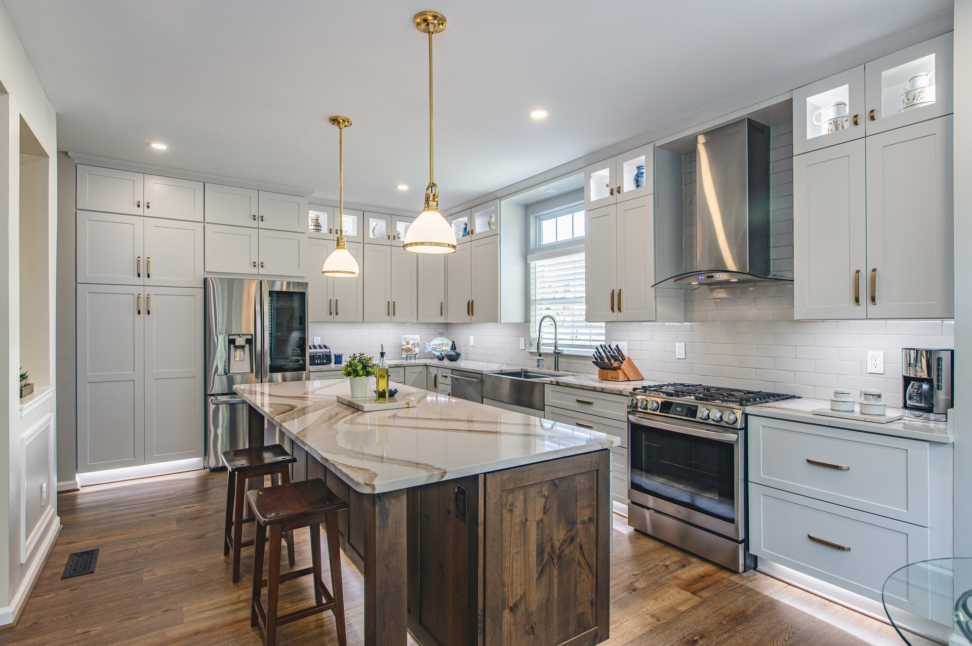 A modern kitchen featuring a central island and elegant wooden flooring, creating a warm and inviting atmosphere