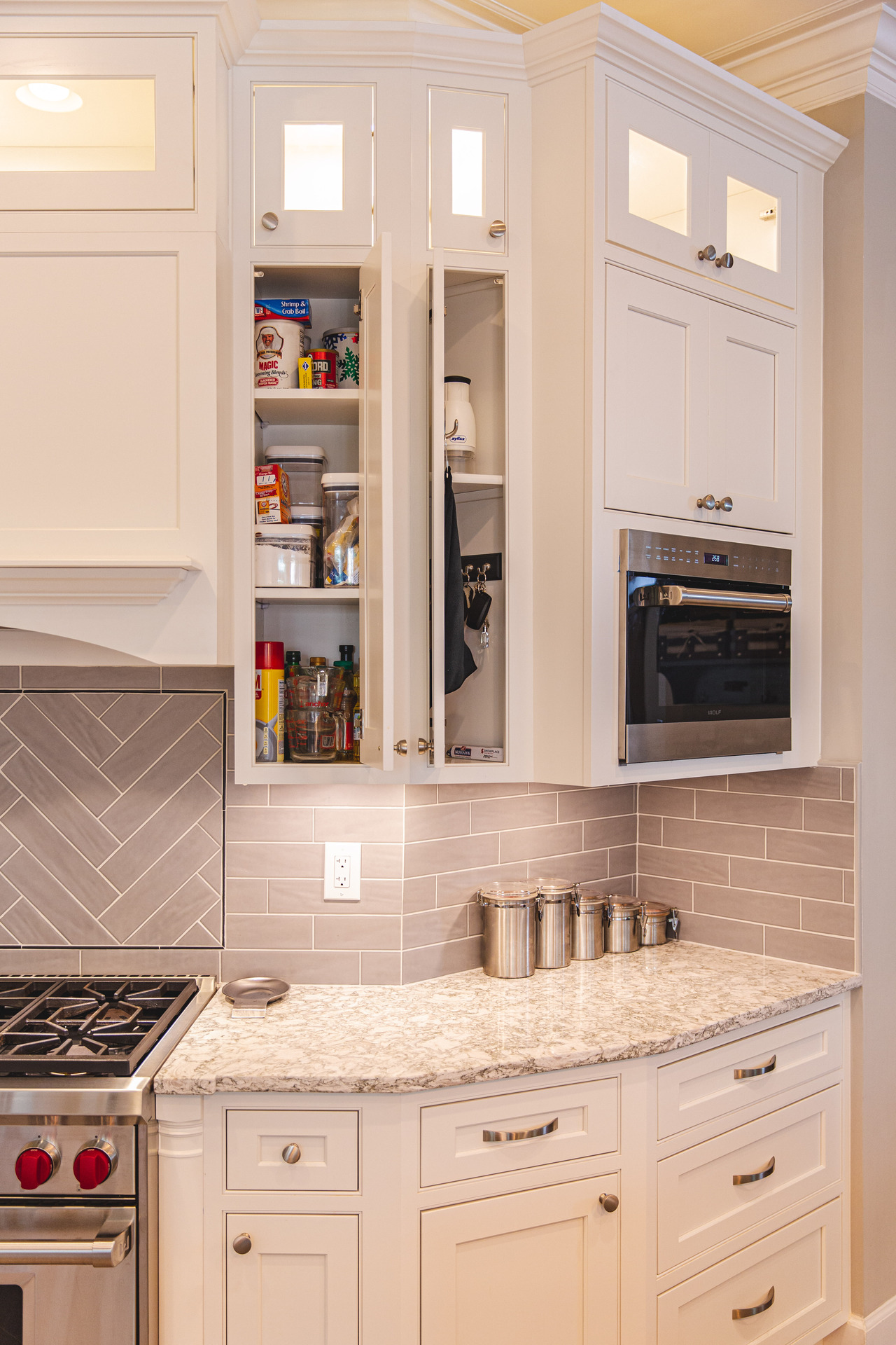 A modern kitchen featuring sleek white cabinets and a stainless steel stove, creating a bright and inviting atmosphere.