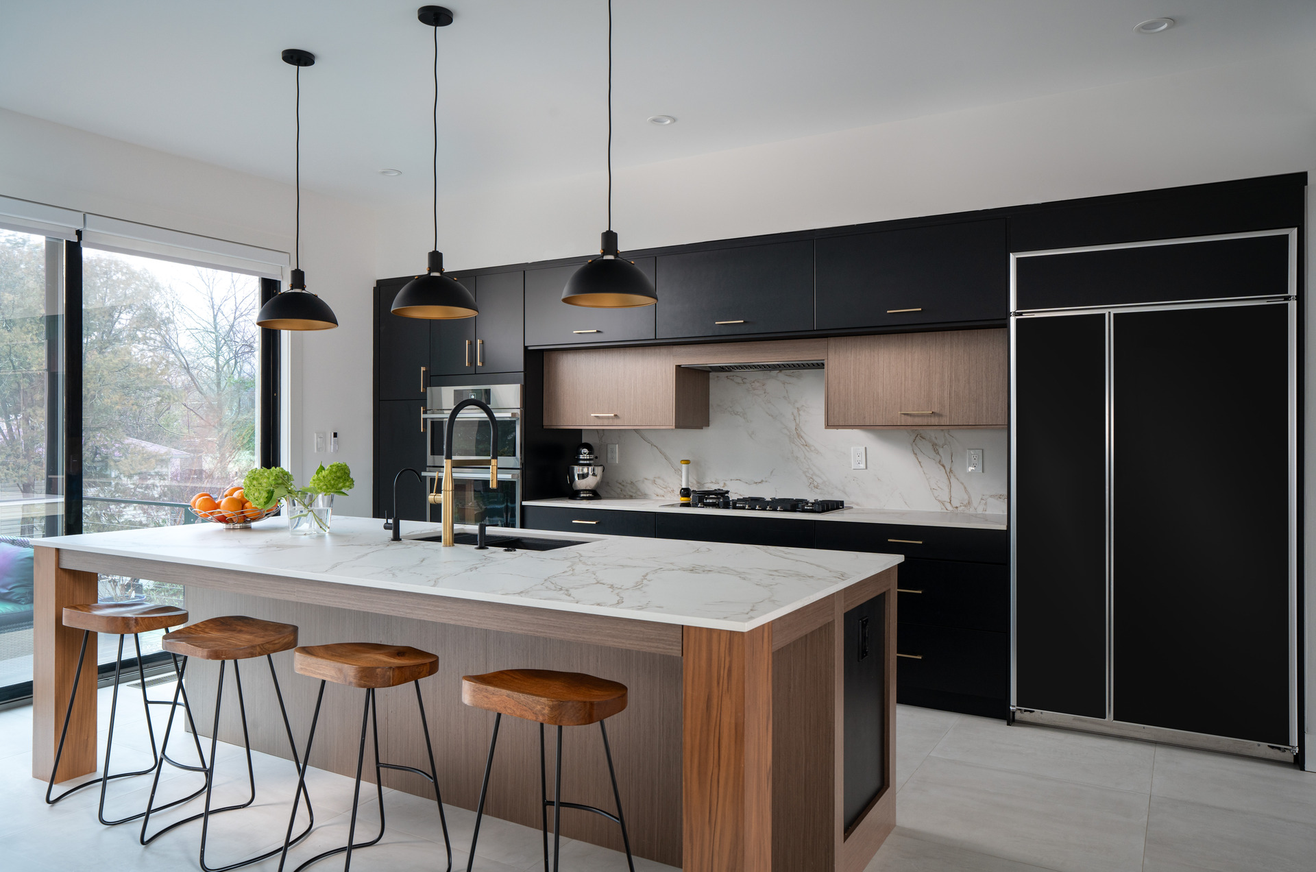 Contemporary kitchen design showcasing elegant black cabinetry and a luxurious marble island.