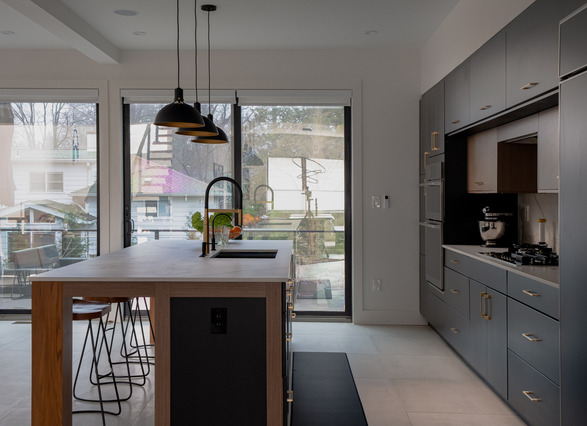 A sleek modern kitchen featuring black cabinets and a stunning marble island as the centerpiece.