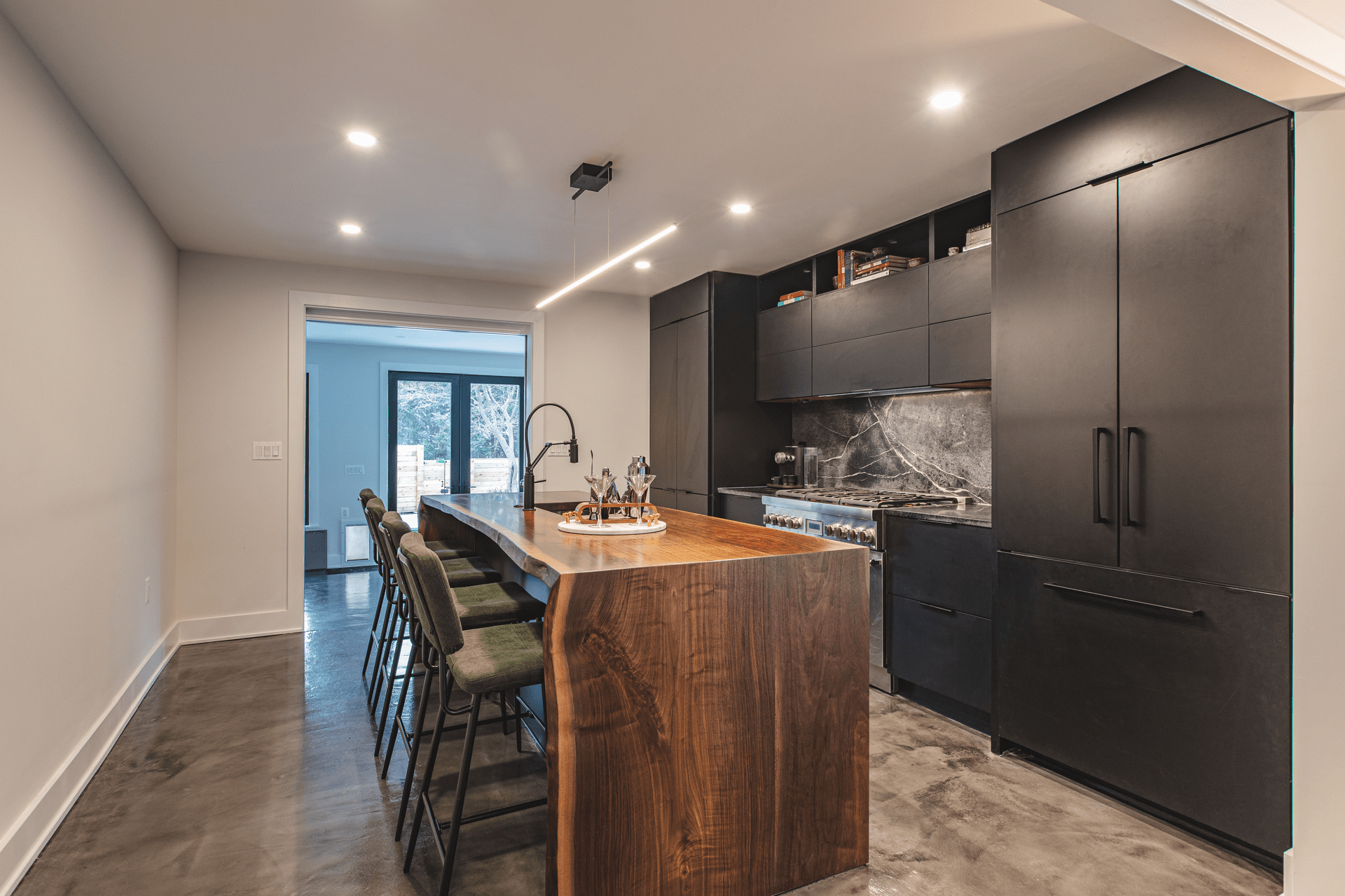 A modern kitchen featuring a sleek counter and a stainless steel sink, showcasing a clean and organized space.