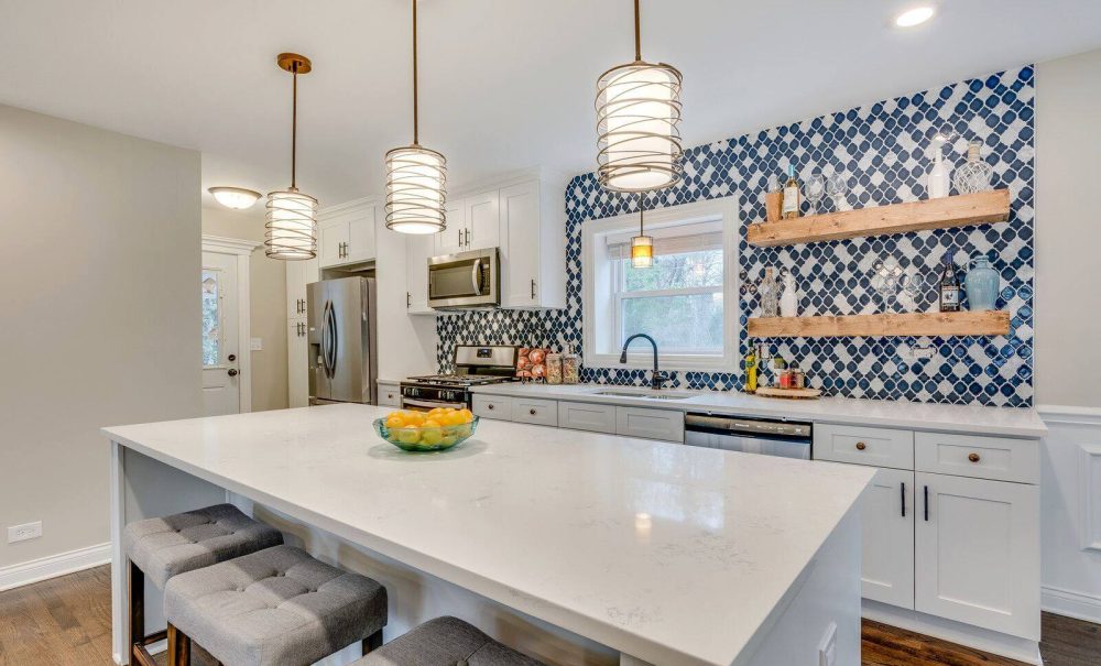 A kitchen featuring blue and white wallpaper complemented by a sleek white countertop, creating a fresh and inviting atmosphere.