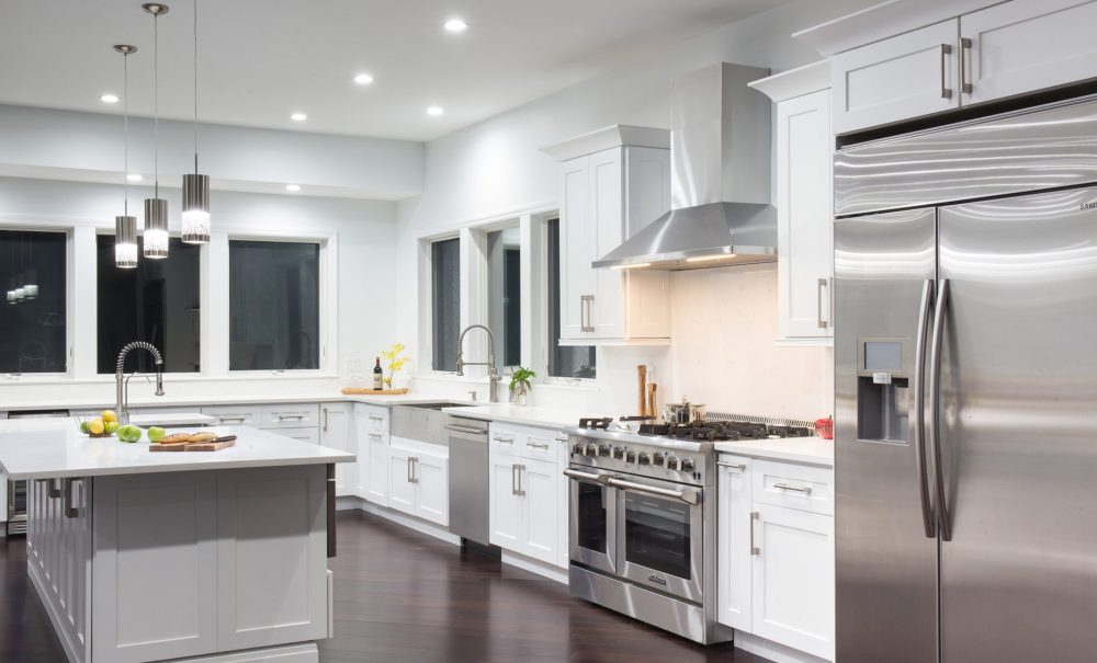 A pristine kitchen featuring sleek stainless steel appliances and elegant white cabinetry, exuding a modern aesthetic.